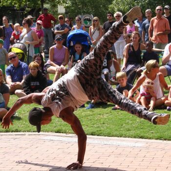 Man breakdances in front of crowd